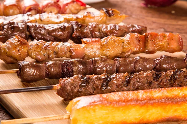 Espetos de bife sortidos em cima de uma tábua — Fotografia de Stock