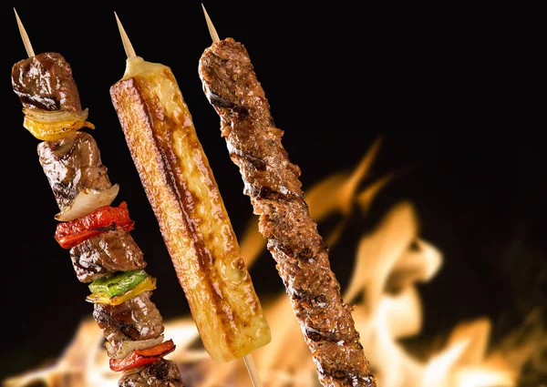 Geassorteerde biefstuk-spiesjes op een achtergrond van brand — Stockfoto