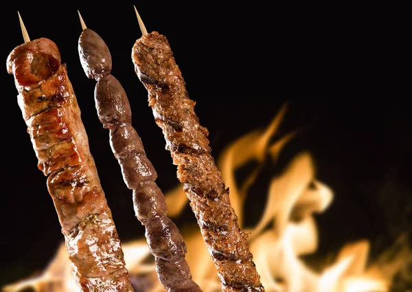 Yangın arka plan üzerinde çeşitli biftek şişleri