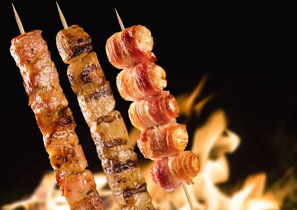 Yangın arka plan üzerinde çeşitli biftek şişleri