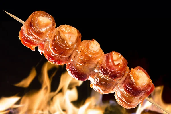 Espetos de frango com bacon em um fundo de fogo — Fotografia de Stock