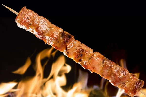 Yangın arka plan üzerinde domuz eti şiş. Panceta