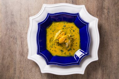 Ahşap bir masa üzerinde tavuk ile Pequi meyve. Frango com pequi.