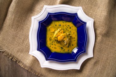 Ahşap bir masa üzerinde tavuk ile Pequi meyve. Frango com pequi.