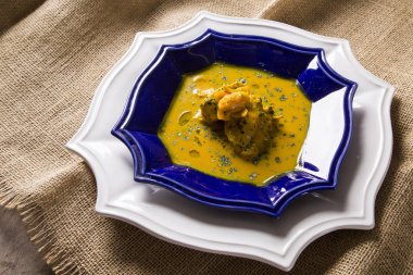 Ahşap bir masa üzerinde tavuk ile Pequi meyve. Frango com pequi.