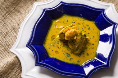 Ahşap bir masa üzerinde tavuk ile Pequi meyve. Frango com pequi.