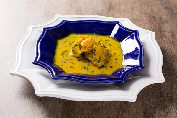 Ahşap bir masa üzerinde tavuk ile Pequi meyve. Frango com pequi.