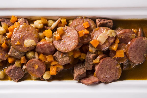 Südamerikanische Küche: Puchero-Suppe mit Wurst. Nahaufnahme im Topf auf dem Tisch. — Stockfoto