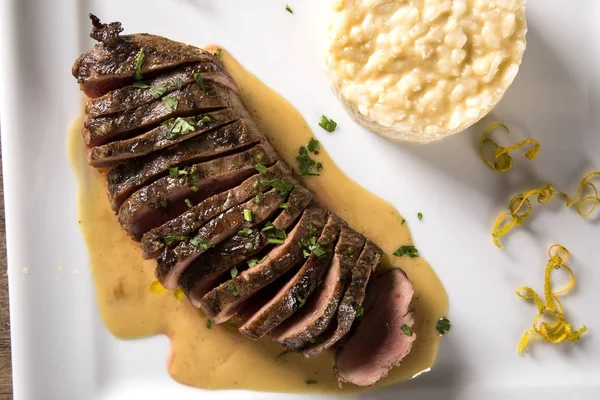 Magret de pato con salsa de tucupi y risotto de jambú . — Foto de Stock