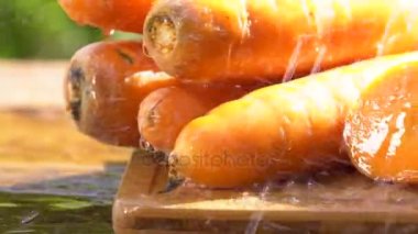 Yeşil salatalık su ile püskürtme ahşap kesme tahtası üzerinde. Süper ağır çekim vurdu 