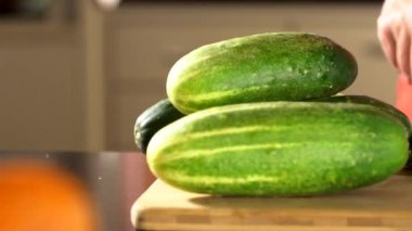 Salatalık Dilimleme kadın. Eller yeşil salatalık yüzük kesti. Büyük bıçak. Mutfakta. Ahşap tahta. House-Proud kadın. Taze salatalık. Taze sebze