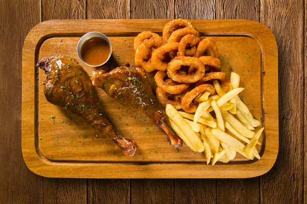 Duck thigh with french fries and onion ring — Stock Photo, Image