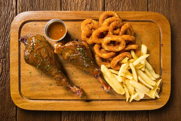 Duck thigh with french fries and onion ring — Stock Photo, Image