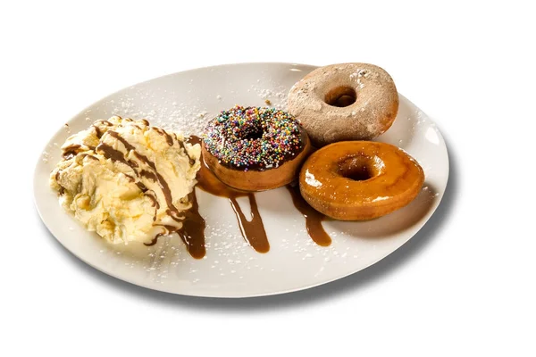 Deliciosos donuts de sobremesa com sorvete em um prato branco com decoração em uma mesa de madeira — Fotografia de Stock