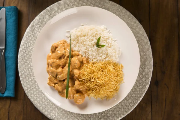 Delizioso cibo sano con pollo strogonoff con riso e patatine fritte sul piatto. Vista dall'alto — Foto Stock