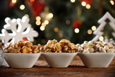 Ceviz taneleri kaju fıstığı ve yaban domuzu bulanık christimas arka plan ile bir kase içinde pistachions