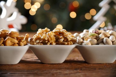 Ceviz taneleri kaju fıstığı ve yaban domuzu bulanık christimas arka plan ile bir kase içinde pistachions