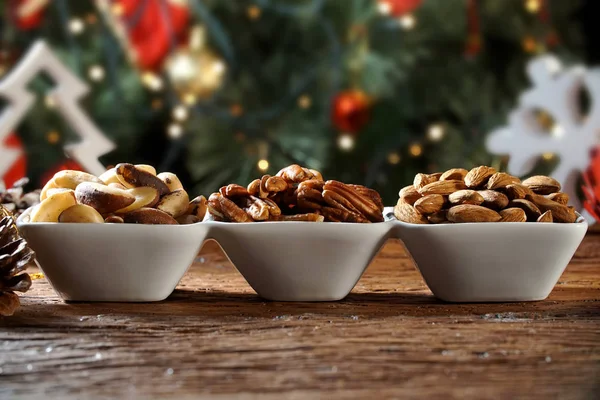Walnut kernels, brazilian nut and almonds in a bowl on rustic old wooden table. — Stock Photo, Image