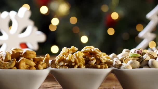 核桃仁腰果和 Pistachions 在一个碗上的板与模糊的圣诞节 — 图库视频影像
