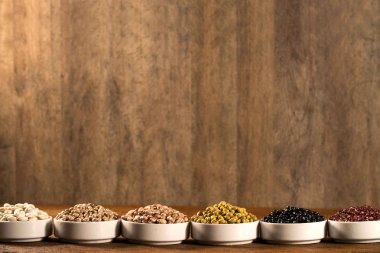 Kase ahşap arka plan üzerinde çeşitli fasulye