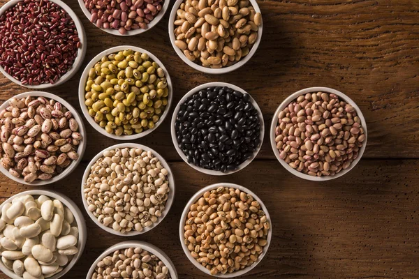 Kase ahşap arka plan üzerinde çeşitli fasulye