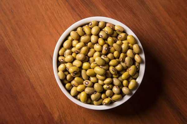 Haricots dans un bol sur fond en bois — Photo