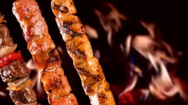 Yangın arka plan üzerinde çeşitli biftek şişleri.