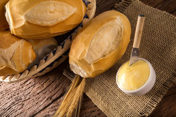 パンのバスケット"フランス語"、伝統的なブラジルのパンにバター ウッドの背景に. — ストック写真