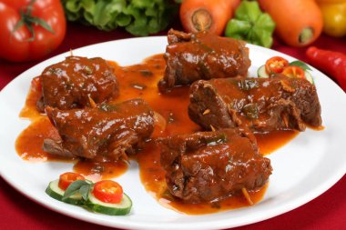 Doldurulmuş sığır eti rulo olarak beyaz bir tabak.