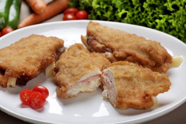 Ekmekli tavuk fileto, mozzarella peyniri ve jambon ile doldurulmuş