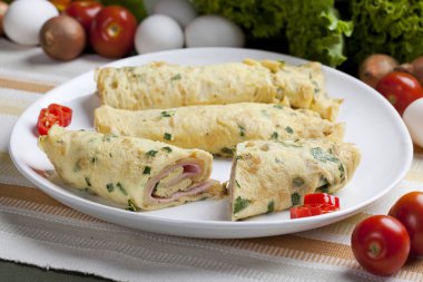 Bir kesme tahtası üzerinde Fransız omlet. Rendelenmiş peynir ve maydanoz yeşil kesme tahtası ile omlet Fransızca. Kahvaltı için bitkilerle diyet omlet. Yemektir, yumurta, peynir ve Yeşiller omlet