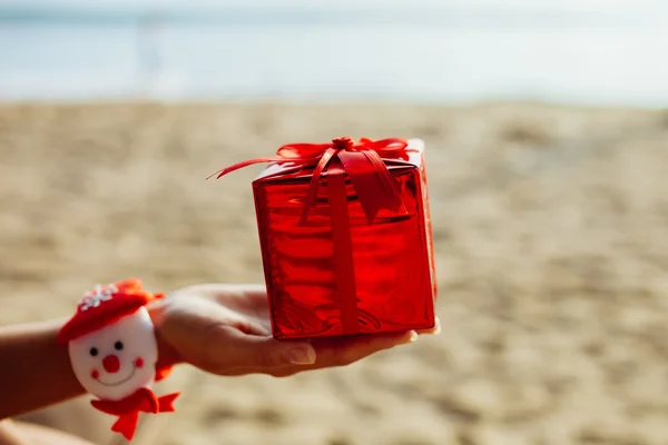 christmas gift in red box on the beach