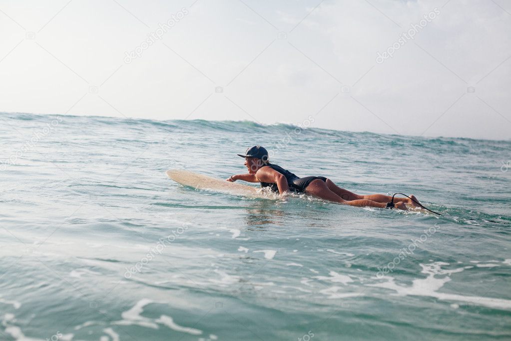 woman surfer swimming in sea