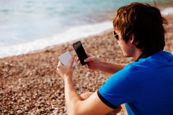 Mann lädt Smartphone mit Powerbank — Stockfoto