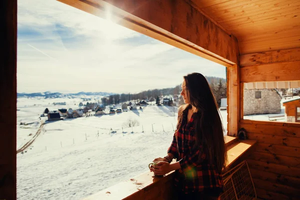 Дівчина п'є чай на зимовій терасі — стокове фото