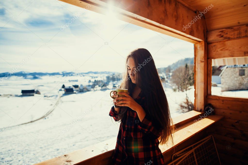 girl drinks tea on winter terrace