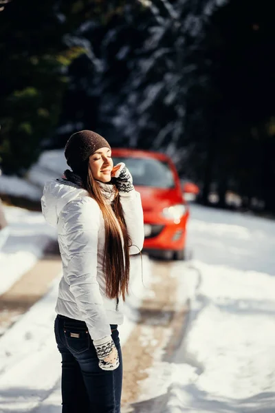 Sexy kobieta podróży samochodem w śnieżnym lesie — Zdjęcie stockowe