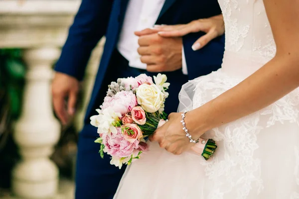 Sposa tenere bouquet da sposa di peonie rosa e rose — Foto Stock