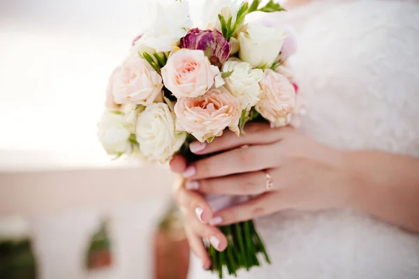 Newlyweds holding wedding bouquet — Stock Photo, Image