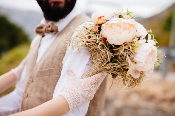 Recém-casados segurando buquê de casamento — Fotografia de Stock