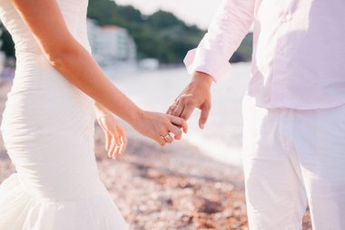 Gelin ve damat el ele tutuşuyorlar.