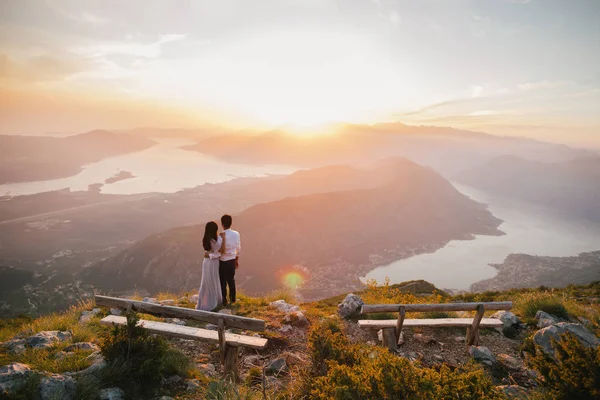 Svatební pár polibek a objetí při západu slunce — Stock fotografie