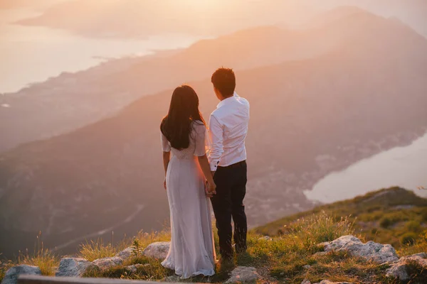 Huwelijksreis paar kussen en omhelzen bij zonsondergang — Stockfoto