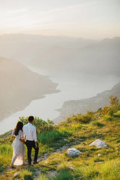 Flitterwochen-Paar küsst und umarmt sich bei Sonnenuntergang — Stockfoto