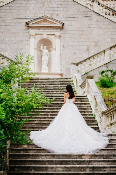 Nevěsta ve svatebních šatech s církevní pozadím — Stock fotografie