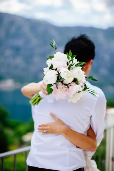 Recém-casados segurando buquê de casamento — Fotografia de Stock