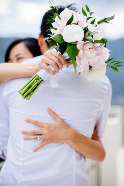 Recém-casados segurando buquê de casamento — Fotografia de Stock