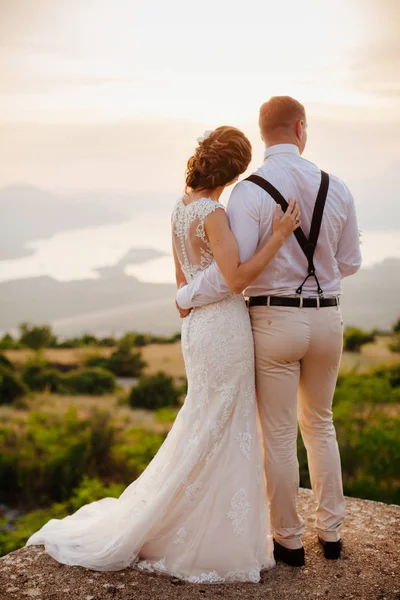 Casal lua de mel abraçar uns aos outros ao pôr do sol — Fotografia de Stock