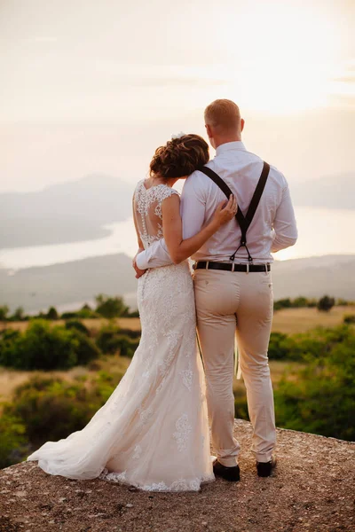 Casal lua de mel abraçar uns aos outros ao pôr do sol — Fotografia de Stock