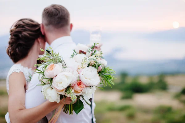 Sposa tenere bouquet da sposa di peonie rosa e rose — Foto Stock